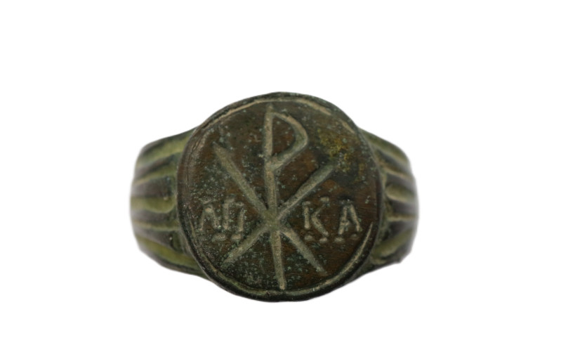 A flat sectioned bronze ring with decorated arms ,oval bezel and CHI RHO Christo...