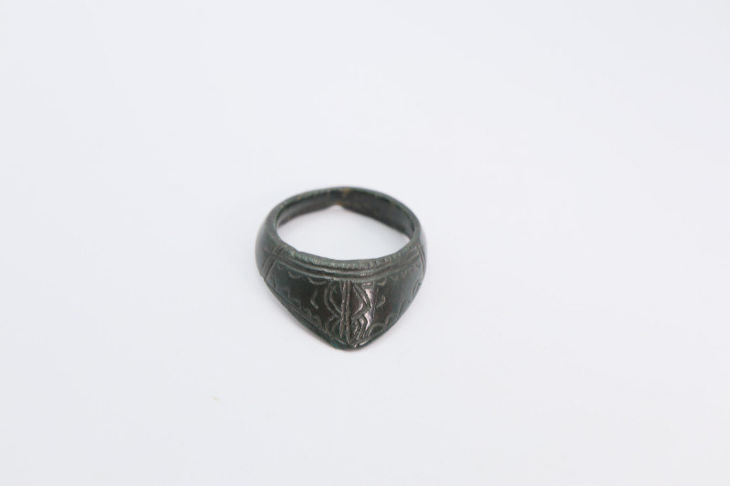 A bronze archer thumb ring with dark-green patina and overall decoration. 22.65 ...