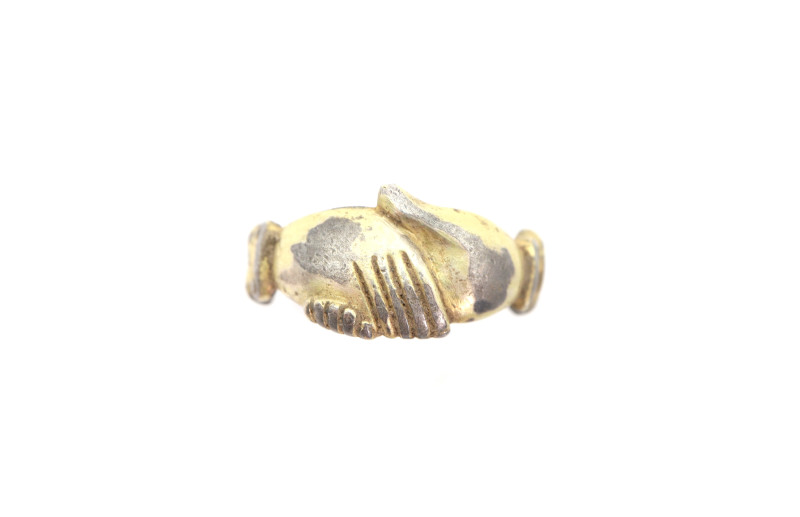 A silver-Partly gilded ring with flat band and bezel formed as clasped hands ; 2...