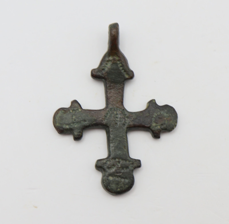 A bronze cross pendant with loop intact and punctual decoration in the forms of ...