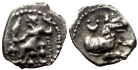 Lycaonia, Laranda AR Obol (Silver, 0.50g, 11mm) ca 324/3 BC. 
Obv: Baaltars seated left, torso facing, holding grain ear and grape bunch in extended r...