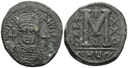 ByzantineJustinian I AE Follis (Bronze) Antioch.Obv: DN IVSTINIANVS PP AVG, helmeted and cuirassed bust facing, holding cross on globe and shield with...