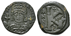 JUSTINIAN I (527-565). Follis.
Obv: D N IVSTINIANVS P P AVG.
Helmeted and cuirassed bust facing, holding globus cruciger and shield decorated with hor...