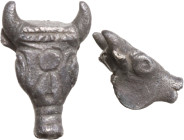 SILVER BULL'S HEAD PENDANT Egypt or Ancient Near East, c. 1st millennium BC. Silver pendant depicting a bull with stylized anatomical details and a sy...
