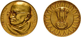 Goldmedaille (29,68g, ca. 35mm), o.J., von Huguenin, auf Mahatma Ghandi. Av: Brustbild Ghandis nach links, darum Umschrift. Rev: Drei Löwen auf Sockel...