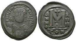 JUSTINIAN I (527-565). Follis.
Obv: D N IVSTINIANVS P P AVG.
Helmeted and cuirassed bust facing, holding globus cruciger and shield decorated with hor...