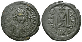 JUSTINIAN I (527-565). Follis.
Obv: D N IVSTINIANVS P P AVG.
Helmeted and cuirassed bust facing, holding globus cruciger and shield decorated with hor...