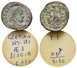 Gratian (367-383). Æ (18mm, 1.95g). Siscia, 367-375. Pearl-diademed, draped and cuirassed bust r. R/ Gratian advancing r., holding labarum and draggin...