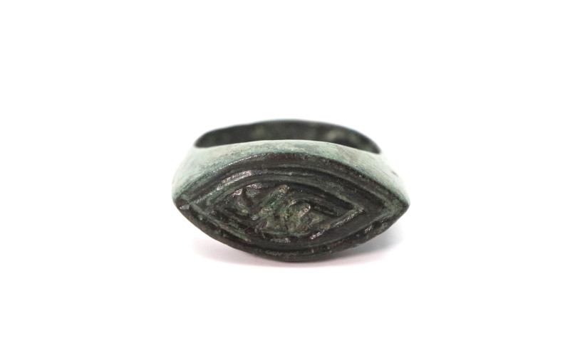 A bronze ring with a solid D sectioned band, ellipsoid bezel with decoration; 9....