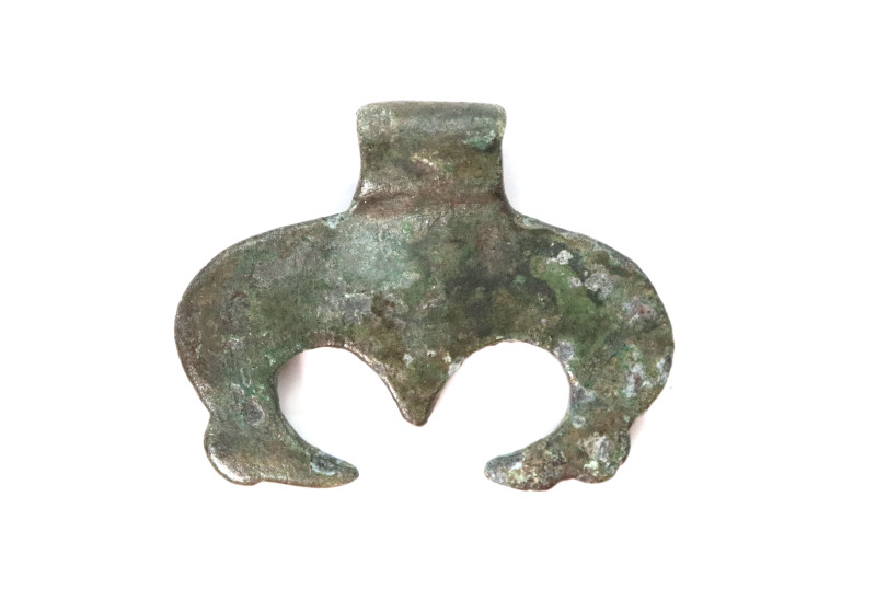 A bronze Migration Period pendant with suspension loop; two stylized animal head...