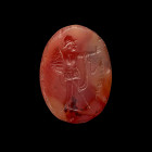 Scaraboid gemstone with Athena. Perhaps Bactria, 2nd - 1st century BC. 3,4 x 2,5 x 1,5cm. Oval intaglio made of transparent to reddish cornelian-onyx ...