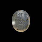 Gemstone with enthroned Jupiter. Middle Roman Imperial Period, 2nd half 2nd century AD. 1,4 x 1,2cm. Oval intaglio made of chalcedony with plain back....