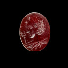 Gemstone with the bust of Mercury. Roman, 2nd half 2nd century AD. 1,5 x 1,2cm. Oval intaglio made of deep red cornelian with plain back. On the sligh...