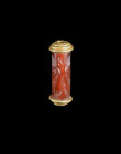 A neobabylonian carnelian cylinder seal showing a winged demon attacking a antelope. About 8th century BC. With original gold setting! Intact. Rollsie...