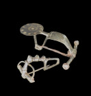 Two bronze fibulae: a) Bow fibula with a foot ending in a disc with punched circles, L 9cm. Hallstatt Culture, about 500 BC. Intact. b) With stongly p...