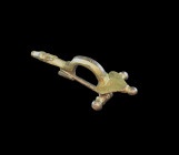 Gilded silver fibula with a foot terminating in a dog's head and triangular head plate and decoration in coldwork and niello, L 7.8cm. Romano-germanic...