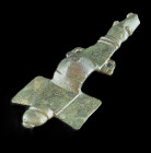 Bronze long brooch, the rectangular head-plate with ridged terminals, two concentric circles on the plate, with arched bow, the foot in form of a styl...