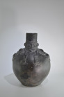 Huari, 800 - 1100 AD. H 33.5cm. Bulbous vessel in form of a shaman with high headdress, whose two stripes end in cat heads with forked tongues; two sn...