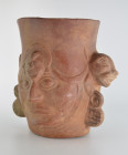 Moche, 800 AD. H 20cm. Red clay. Head of a dignitary with large earrings and a high hood closed under the chin. At the top of his forehead rises the h...