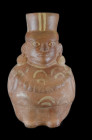 Moche, 300 - 700 AD. H 25cm. Reddish clay painted in red and beige. Large beaker in form of a crouching man who wears a poncho, a small bag on the bac...