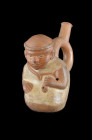 Moche, 100 - 300 AD. H 16.7cm. Reddish clay painted in beige and red. Stirrup vessel in form of a sitting human figure wearing a head band and holding...