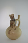 Moche, 500 AD. H 27.5cm. Clay with beige and reddish paint. Stirrup vessel with a crouching man wearing a tunic and having a bundle strapped to his ba...