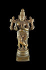 Heavy statuette of the four-armed Krishna. India, 18th century. Height 22,5cm. Bronze statuette in light copper colour of the standing Krishna in cano...