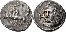 Syracuse. Tetradrachm, signed by Eukleidas circa 405-400, AR 17.27 g. Fast quadriga driven l. by female charioteer, holding reins in l. hand and raisi...