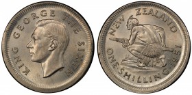 NEW ZEALAND: George VI, 1937-1952, copper-nickel shilling, 1951, KM-17, broadstruck mint error, plain edge, PCGS graded MS63, RR. A perfectly centered...