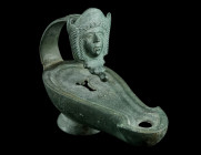A ROMAN BRONZE OIL LAMP WITH THEATRE MASK FINAL
Circa 1st-2nd century AD.
Fine bronze lamp with pear-shaped body and central filling hole, the flaring...