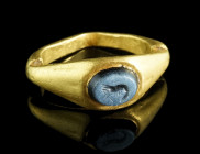 A ROMAN GOLD RING WITH A NICOLO INTAGLIO DEPICTING A SHRIMP
Circa late 2nd-3rd century AD.
Ring with flared and angled shoulders, the oval bezel set w...