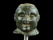 A ROMAN BRONZE BUST OF AN ATHLETE
Circa 2nd-3rd century AD.
Steelyard weight in the form of the bust of an athlete wearing a cap. He features short ha...
