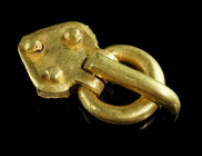A EUROPEAN MIGRATION PERIOD SOLID GOLD BUCKLE
Circa 5th century AD.
Heavy gold buckle with long, curved thorn and lozenge-shaped plate with three rive...