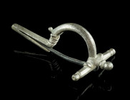 A ROMAN SILVER EARLY CROSSBOW BROOCH
Circa 3rd century AD.
So-called 'Scharnierarmfibel', a precursor of the classical crossbow brooch. With arched bo...