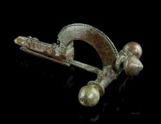 A LATE ROMAN BRONZE CROSSBOW BROOCH
Circa 4th century AD.
With arched bow and onion-shaped terminals ('Zwiebelknöpfe'). The top of the bow, the foot, ...
