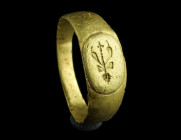 A ROMAN GOLD RING WITH A THYRSOS
Circa 2nd century AD.
Ring with flared shoulders and slightly raised oval bezel depicting a thyrsos, a staff with a t...