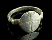 A BYZANTINE SILVER GILT RING WITH A CROSS
Circa 10th-12th century AD.
Ring with ridged shoulders and offset round bezel engraved with an ornamental cr...
