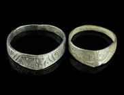TWO VERY SMALL MEDIEVAL SILVER ARCHERS' RINGS
Circa 14th-15th century AD.
Two silver archers' rings with flat-section hoop and triangular extension. B...