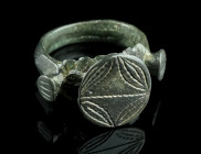 A LATE MEDIEVAL/EARLY MODERN BRONZE RING
Circa 15th-16th century AD.
With a projecting oval bezel decorated with an ornamental design.
Ring size 57 (E...
