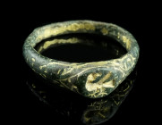 A MEDIEVAL GILT BRONZE STIRRUP RING WITH AN EAGLE
Circa 12th-13th century AD.
Ring with an oval bezel depicting a crouching eagle with spread wings an...