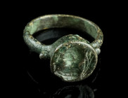 A SMALL LATE ROMAN BRONZE RING WITH A MALE BUST
Circa 4th century AD.
Ring with projecting circular bezel depicting a draped male bust to left, a bran...