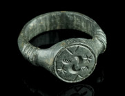A LATE MEDIEVAL/EARLY MODERN BRONZE RING
Circa 15th-16th century AD.
With a projecting round bezel decorated with an ornamental design.
Ring size 57 (...