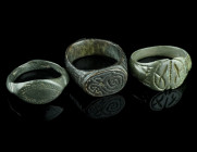 THREE MEDIEVAL/EARLY MODERN BRONZE RINGS
Circa 14th-17th century AD.
Three rings of different shape and design with incised decoration.
Ring size 55-5...