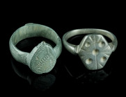 TWO LATE MEDIEVAL/EARLY MODERN BRONZE RINGS
Circa 15th-17th century AD.
Both with an offset bezel decorated with an ornamental design.
Ring size 58 (E...