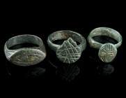 THREE MEDIEVAL/EARLY MODERN BRONZE RINGS
Circa 14th-17th century AD.
Three rings of different shape and design with incised decoration.
Ring size 54-5...