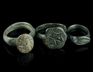 THREE MEDIEVAL/EARLY MODERN BRONZE RINGS
Circa 14th-17th century AD.
Three rings of different shape and design with incised decoration.
Ring size 48-5...