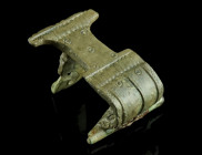 A ROMAN BRONZE VOLUTE KNEE BROOCH
Circa 2nd-3rd century AD.
Knee brooch with a volute bow design and a high transverse catch plate. The wide bow is de...