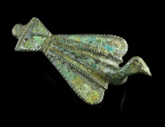 A ROMAN TINNED AND ENAMELLED BRONZE BIRD BROOCH
Circa 2nd century AD.
Brooch in the form of a bird with folded wings. Wings and tail inlaid with colou...