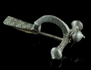 A LATE ROMAN BRONZE CROSSBOW BROOCH
Circa 4th century AD.
With arched bow and onion-shaped terminals ('Zwiebelknöpfe'). The top of the bow is decorate...