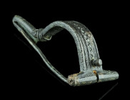 A ROMAN BRONZE BOW BROOCH WITH BENT FOOT
Circa 3rd century AD.
Brooch with folded foot (umgeschlagenem Fuß) and punched decoration along the bow. A sm...